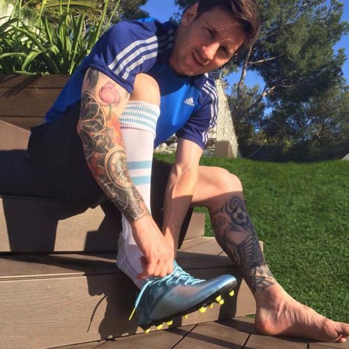 Messi-showing-his-sleeve-and-leg-tattoos