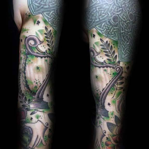 23 full sleeve irish themed tattoo on man with harp and knots