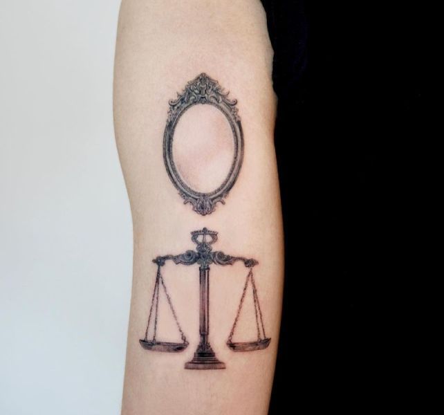 Mirror with Brass Scale Tattoo Design on Upper Arm 