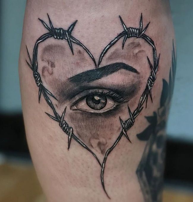 An Eye Surrounded By A Barbed Wire In A Shape Of Heart On The Body