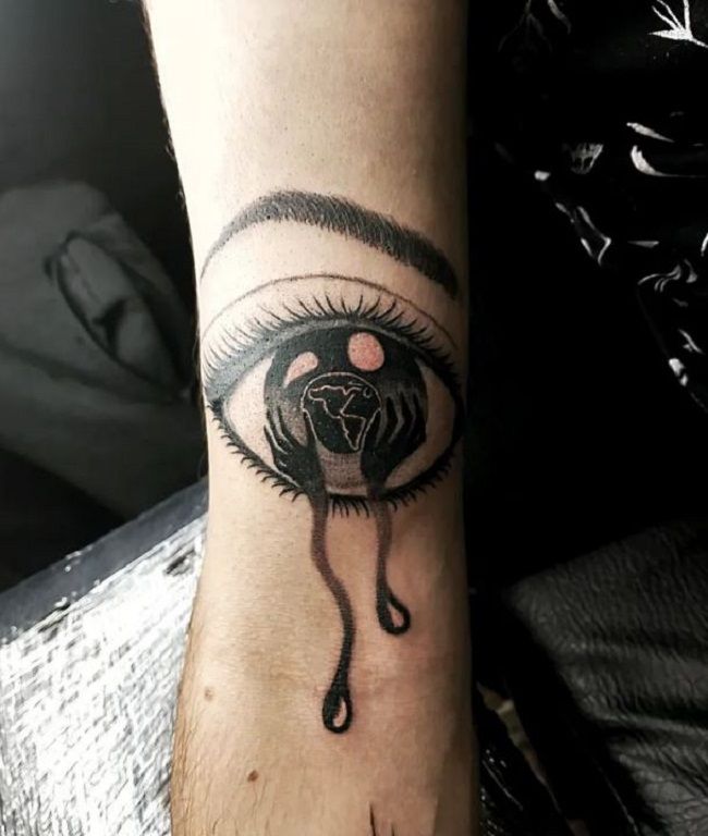 Hand Holding An Eye Tattoo On The Back Of The Wrist