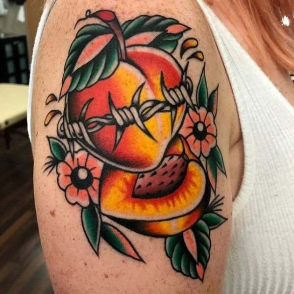 Minimalist peach tattoo on the bicep